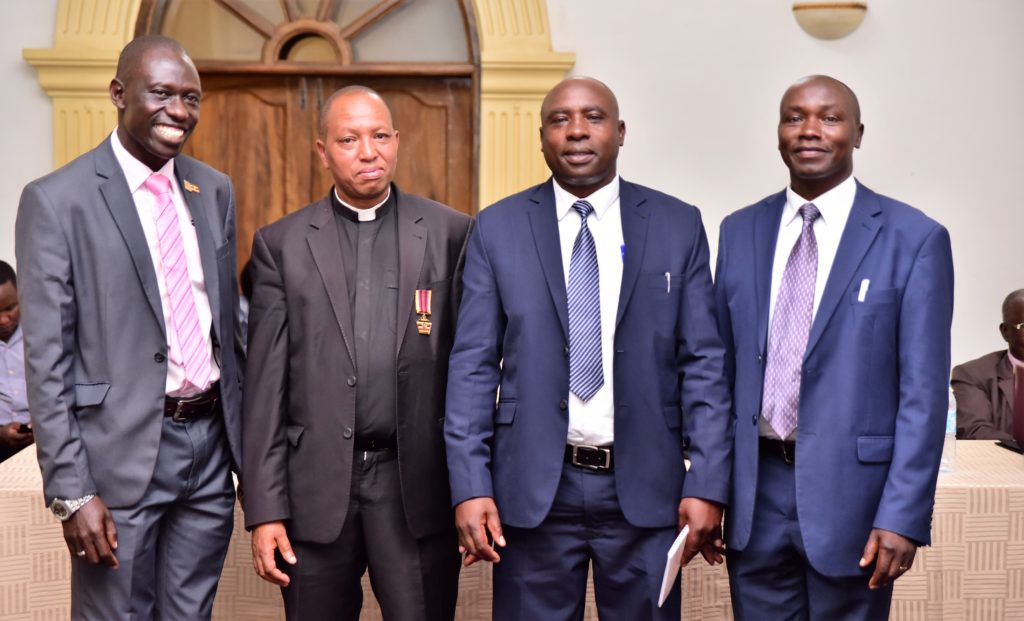 Left to right Mr Jacan Oyenya -Vice Chairperson, Fr. Safari Emmanuel – Treasure, Mr Johnas Tweyambe- Chairman and H.W Geoffrey Seyekwo – Board Member Image